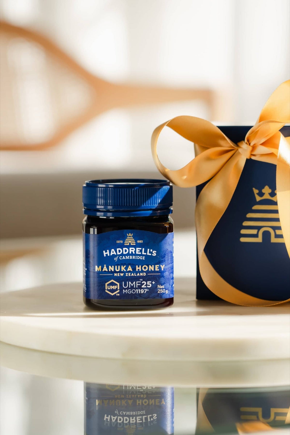 Słoik miodu manuka Haddrell's UMF 25⁺ 250 g przed pudełkiem prezentowym